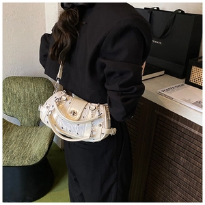 Détail d'un sac à bandoulière blanc avec monogramme lapin et chaîne métallique