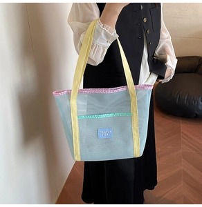 Close-up of mesh beach bag with vibrant yellow straps and blue woven label detail
