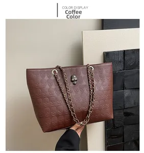 Coffee leather tote bag featuring skull embossed pattern and metal chain handle details