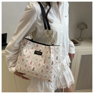 Détail du sac à motif dessin animé avec bandoulière en cuir noir et chaîne en métal doré