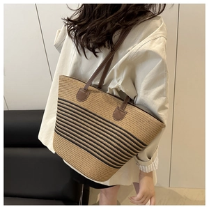 Détail du sac seau en paille de style coréen avec rayures contrastées et anses en cuir