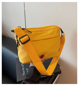 Dettaglio della borsa a tracolla in nylon giallo con ampia cinghia e scomparto a zip
