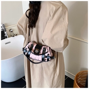 Détail d'un sac cylindrique rose et noir avec fermoir métallique et bandoulière chaîne