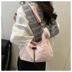Detail of pink pleated hobo bag with matching round coin purse and textured fabric strap