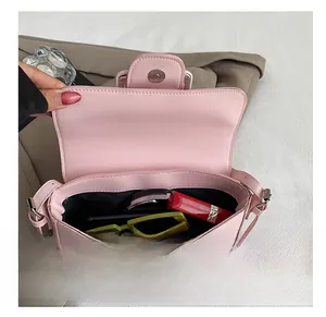 Internal view of pink shoulder bag showing capacity for lipstick and sunglasses