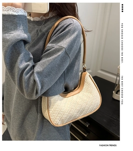 Détail du sac croissant tissé main avec bordure en cuir marron et fermeture éclair métal