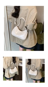 Close-up of beige glossy moon bag showing adjustable strap and patent leather texture