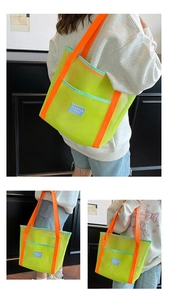 Detail view of large neon mesh beach tote bag with orange shoulder straps and blue label