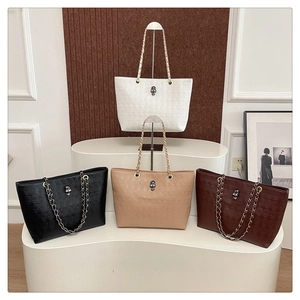 French luxury tote bags featuring skull embossed textures and metal chain straps