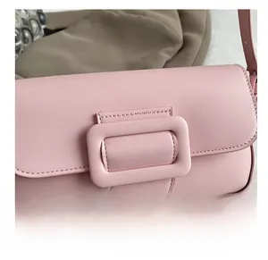 Detail of light pink shoulder bag with large square buckle and neat stitching