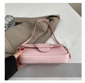 Detail showing the wear-resistant flat bottom of a pink faux leather baguette handbag