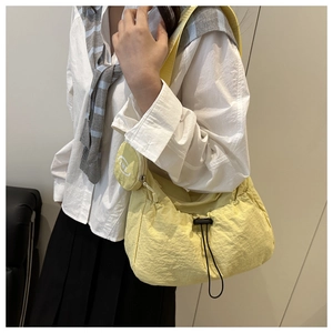 Detail of light yellow nylon tote bag with drawstring closure and small coin purse