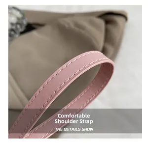Detail of pink leather shoulder strap with white stitching on high-density nylon bag