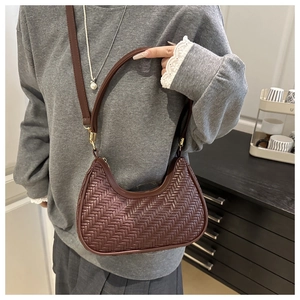 Detail of dark brown woven crescent bag showing the fine leather braiding and strap