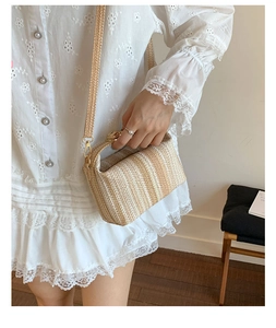 Détail du sac à main en paille avec poignée en bambou, fermoir doré et bandoulière réglable
