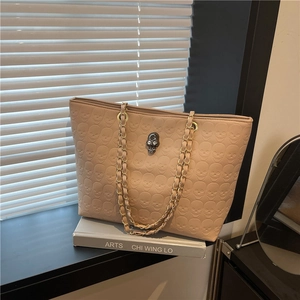 Minimalist beige tote bag with skull embossed pattern and gold chain handles