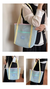 Detail of blue nylon mesh tote bag featuring yellow straps and pink piping trim