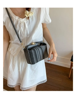 Gros plan sur un sac bandoulière tissé à rayures avec fermoir en métal doré