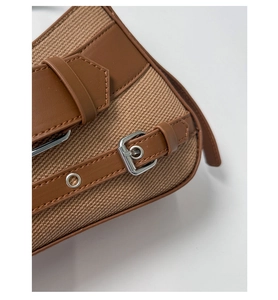 Macro shot of vintage canvas texture and brown leather details on a retro saddle bag