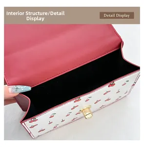 Top view of cherry print handbag showing internal single compartment and gold clasp lock
