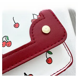 Detail display of white cherry print leather with red textured flap and gold metal snap