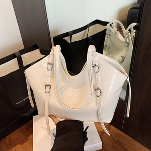 Minimalist white patent leather tote bag with silver buckle details and long dual straps