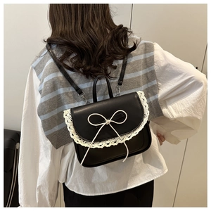 Detail of sweet Lolita style black PU mini backpack with white lace trim and bow detail
