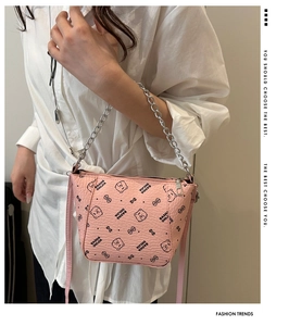 Side view of a pink bucket bag with bear print, showing metal chain and shoulder strap