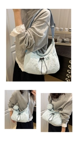 Detail of light blue nylon crossbody bag featuring drawstring pleats and coin purse