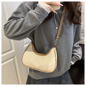Détail d'un sac bandoulière tissé en forme de demi-lune avec garniture en cuir brun