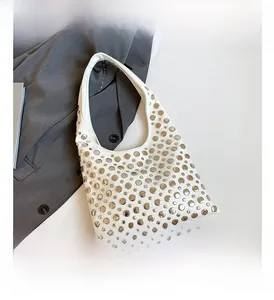 Detail of white hobo bag featuring polished silver round studs and smooth vegan leather