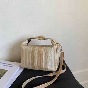 Détail d'un sac à main tissé rayé avec boucle en métal doré et bandoulière amovible