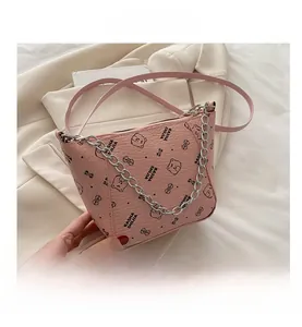 Close-up of pink bucket bag with cartoon bear prints and silver decorative chain strap