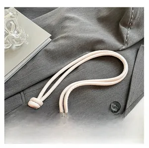 Detail of soft beige leather strap with knotted design and elegant gold metal end caps