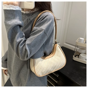 Détail du sac hobo tissé présentant une texture crème et des bordures en cuir marron