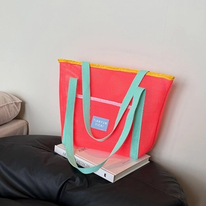 Mesh swimming tote bag with pink honeycomb pattern and green handles for beach travel