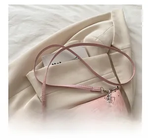 Detailed view of pink bucket bag with bear print and decorative silver chain strap