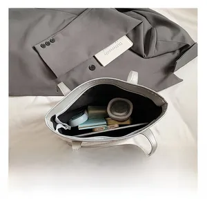 Top view of spacious interior of silver-grey tote bag filled with daily essentials