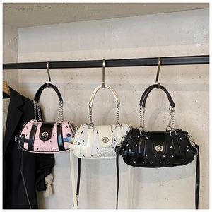 Vue détaillée de trois sacs cylindriques en rose, blanc et noir avec texture gaufrée