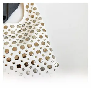 Close-up of premium white leather bucket bag with detailed silver rivet metal studs