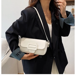 Detail of white minimalist crossbody bag with oversized tonal square buckle on suit