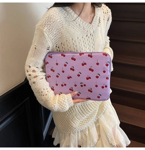 Detailed view of lavender cherry laptop sleeve held by a model for a fresh summer look