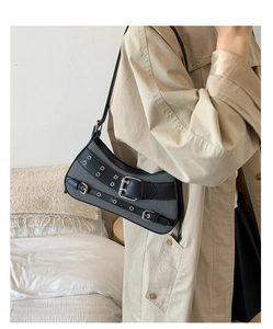 Detail of vintage industrial chic shoulder bag with canvas texture and silver grommets