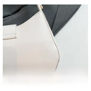 Detailed close-up of smooth white leather bag side showing fine stitching and gold zipper