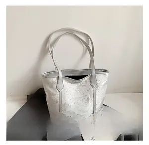 Detail showing shiny silver floral texture on a spacious commute tote bag