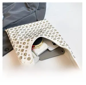 Macro view of large white bucket bag showing spacious interior with rivets