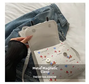 Detailansicht des Magnetverschlusses für den weißen Rucksack mit Cartoon-Muster.