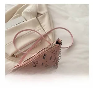 Detailed view of pink leather bucket bag with cartoon bear print and silver chain strap