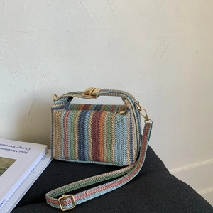 Détail du sac bandoulière tissé à rayures colorées avec boucle dorée et poignée