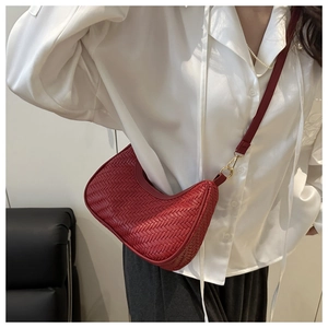 Dettaglio della borsa hobo rossa con trama intrecciata e gancio in metallo dorato